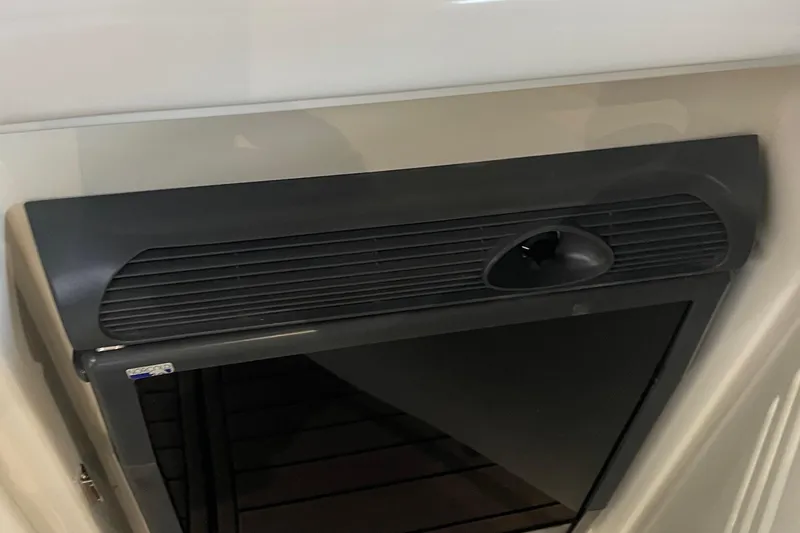 Slide: The Image of 2007 Sea Ray 38 Sundancer cabin interior with black vent and storage compartment. - 26