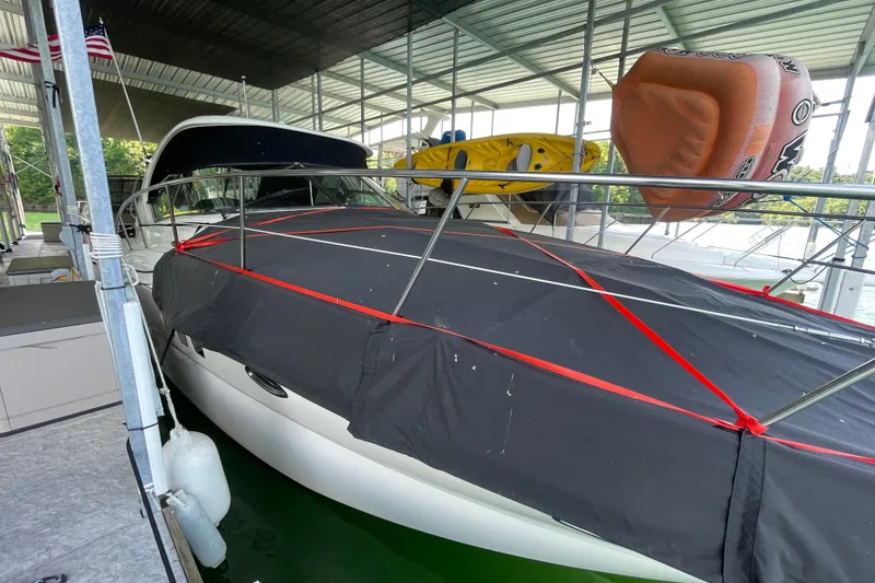 Slide: The Image of 2007 Sea Ray 38 Sundancer docked, covered with black tarp, inflatable water toys on top. - 29