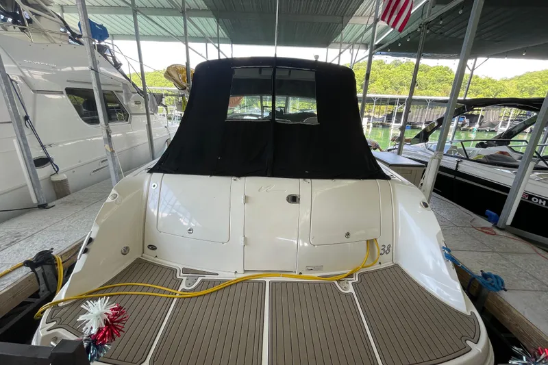 Slide: The Image of 2007 Sea Ray 38 Sundancer docked, rear view with covered cockpit and American flag. - 3