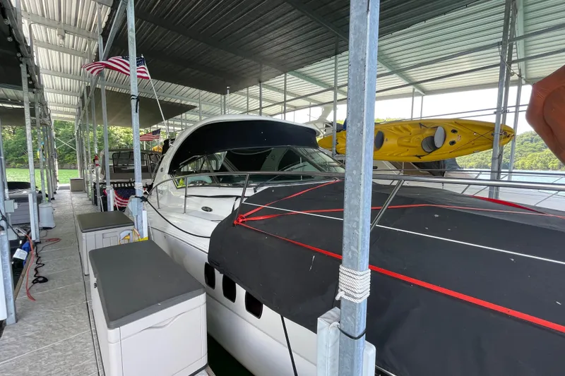 Slide: The Image of 2007 Sea Ray 38 Sundancer docked under a covered marina with kayaks on top. - 30
