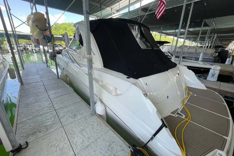Slide: The Image of 2007 Sea Ray 38 Sundancer docked in a marina, covered with a black canopy. - 4