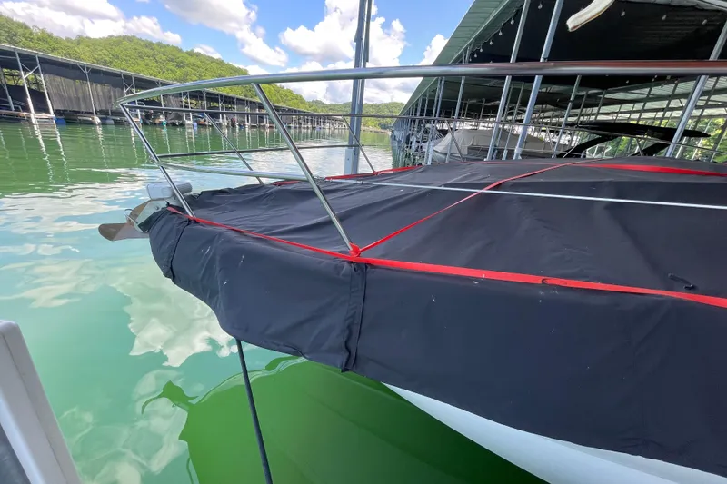 Slide: The Image of 2007 Sea Ray 38 Sundancer docked, covered with black and red tarp, under a marina canopy. - 5