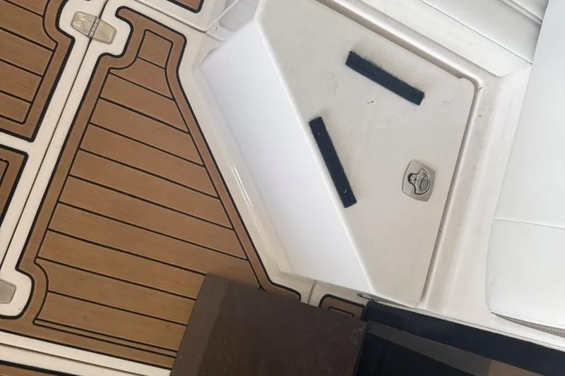 Slide: The Image of 2016 Regal 46 Sport Coupe deck with wood finish and storage compartment. - 14