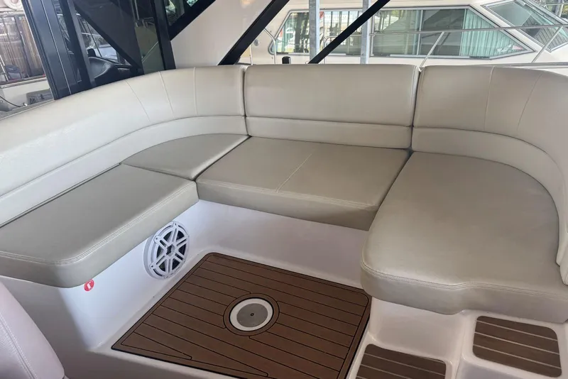 Slide: The Image of Luxurious seating area on a 2016 Regal 46 Sport Coupe yacht, featuring beige cushions. - 19