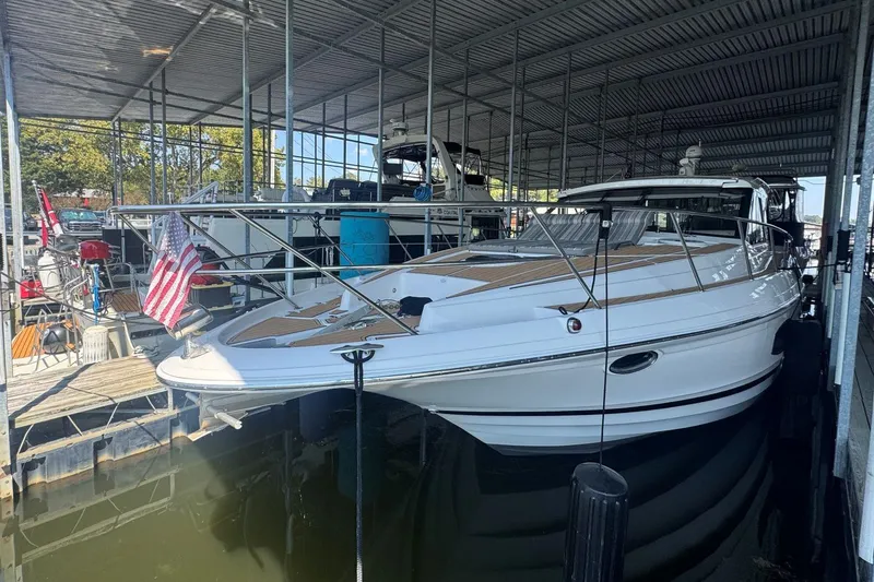 Slide: The Image of 2016 Regal 46 Sport Coupe docked in a covered marina, featuring sleek design and American flag. - 2