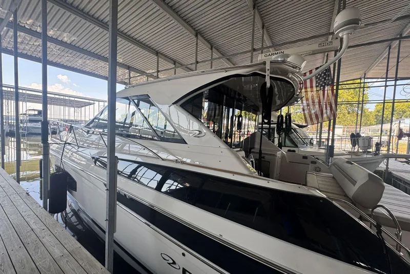 Slide: The Image of 2016 Regal 46 Sport Coupe yacht docked in a marina under a covered structure. - 3