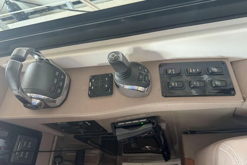 Slide: The Image of Control panel of a 2016 Regal 46 Sport Coupe yacht, featuring joystick and switches. - 30