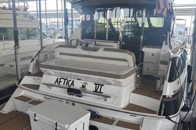 Slide: The Image of 2016 Regal 46 Sport Coupe yacht docked, featuring spacious seating and elegant design. - 5