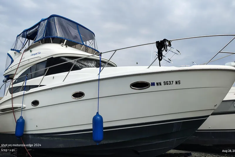 Slide: The Image of 2007 Meridian 341 Sedan yacht with blue canopy, docked with fenders. - 15