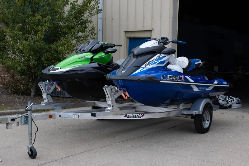 Slide: The Image of 2021 Yamaha WaveRunner GP1800R SVHO on trailer beside green jet ski. - 0