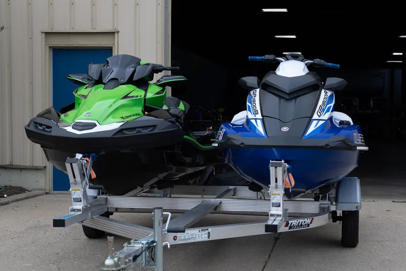 Slide: The Image of Two jet skis on a trailer: 2021 Yamaha WaveRunner GP1800R SVHO and a green Kawasaki. - 1