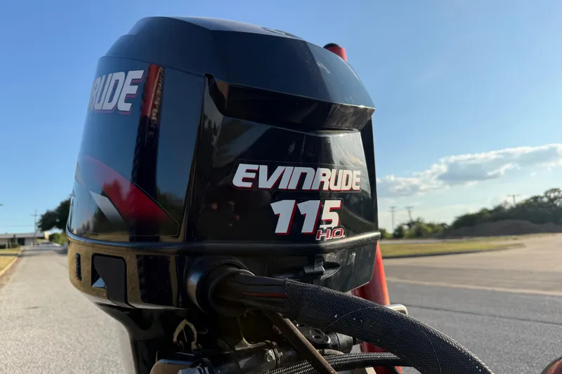 Slide: The Image of 2013 Ranger Z117 boat with Evinrude engine, parked outdoors on a sunny day. - 11