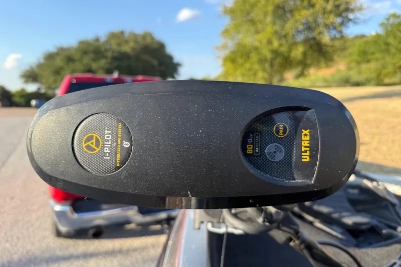 Slide: The Image of 2013 Ranger Z117 boat on trailer by a lake, featuring Evinrude motor. - 16