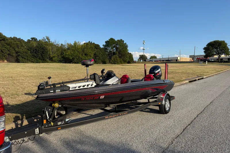 Slide: The Image of 2013 Ranger Z117 boat on trailer by the water, featuring Evinrude engine. - 3
