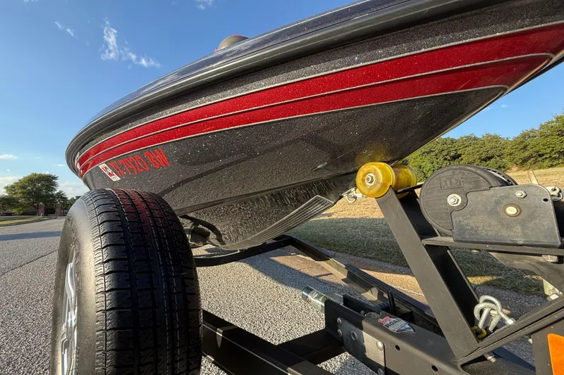 Slide: The Image of 2013 Ranger Z117 boat on trailer, parked outdoors, attached to a red truck. - 32