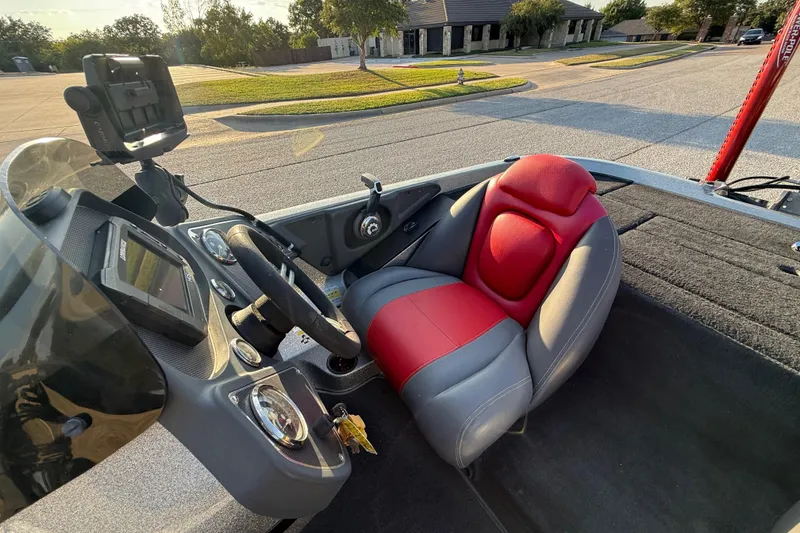 Slide: The Image of 2013 Ranger Z117 fishing boat with red and black seats on a street. - 39