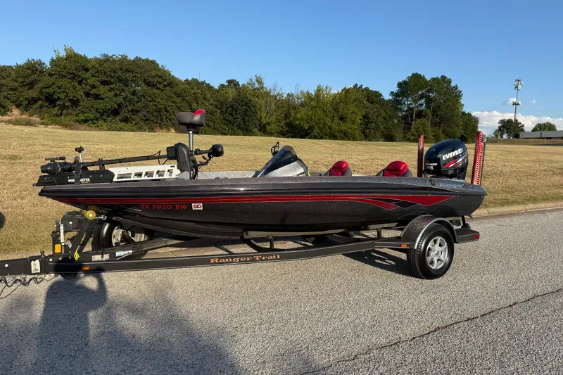 Slide: The Image of 2013 Ranger Z117 boat on trailer by lake, featuring Evinrude engine. - 4