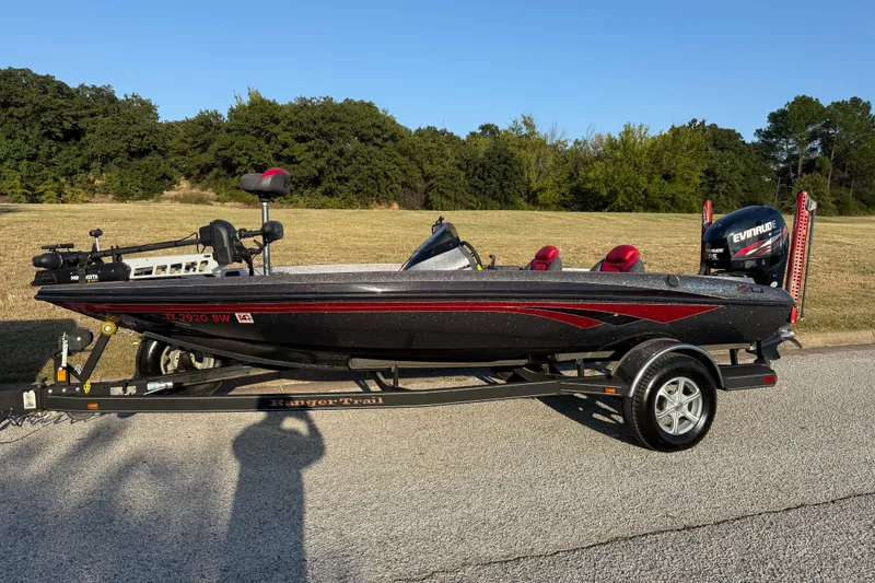 Slide: The Image of 2013 Ranger Z117 boat on trailer by the water, featuring Evinrude motor. - 5