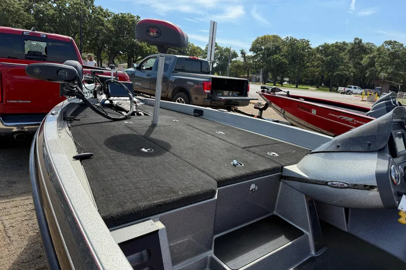 Slide: The Image of 2013 Ranger Z117 boat on trailer, parked near trucks, ready for transport. - 61