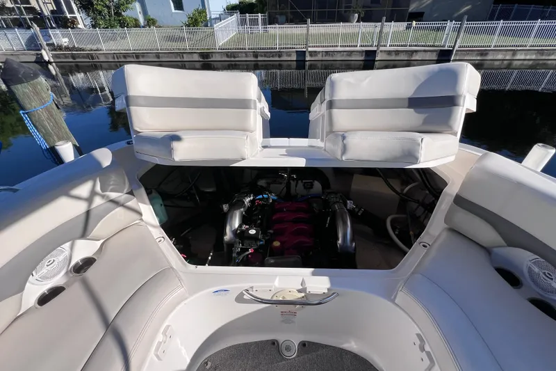 Slide: The Image of 2006 Chaparral 256 SSi boat engine compartment with open seating, docked by water. - 39