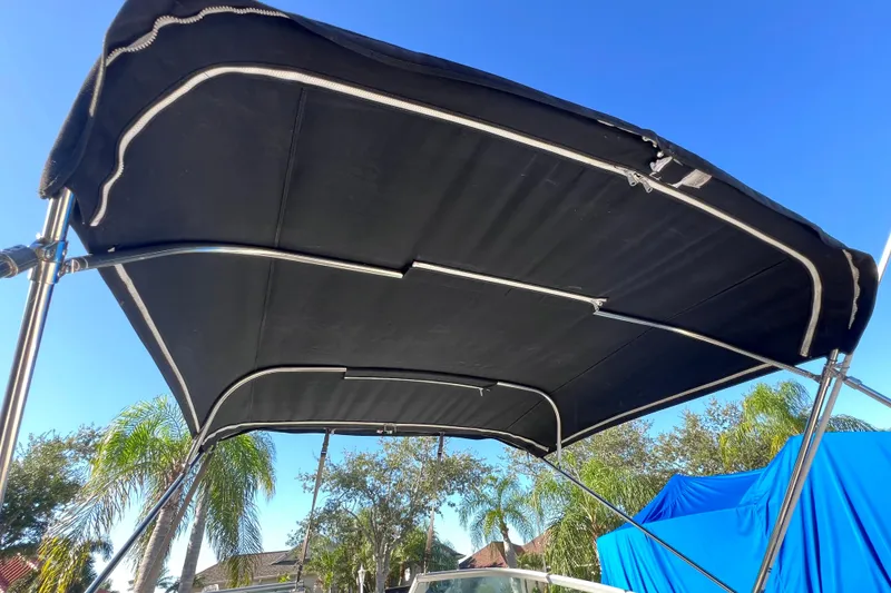 Slide: The Image of Black bimini top on 2006 Chaparral 256 SSi boat under clear blue sky. - 47