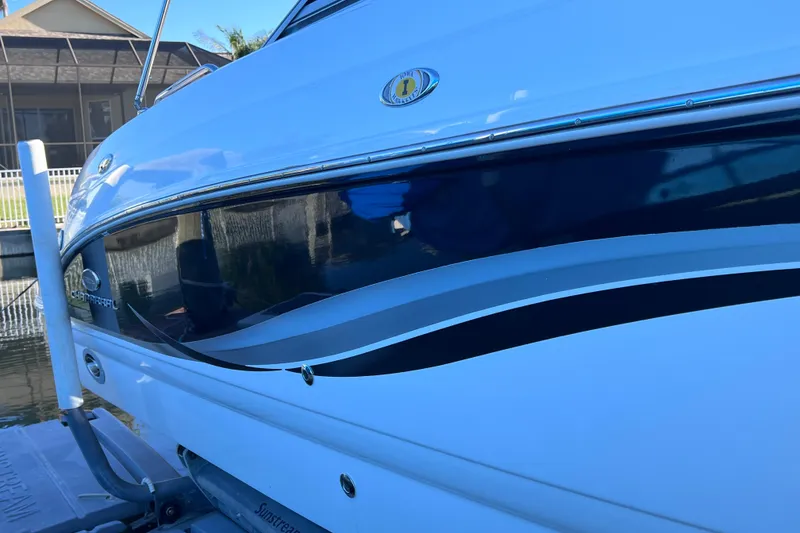 Slide: The Image of 2006 Chaparral 256 SSi boat docked, showcasing sleek design and glossy finish. - 5