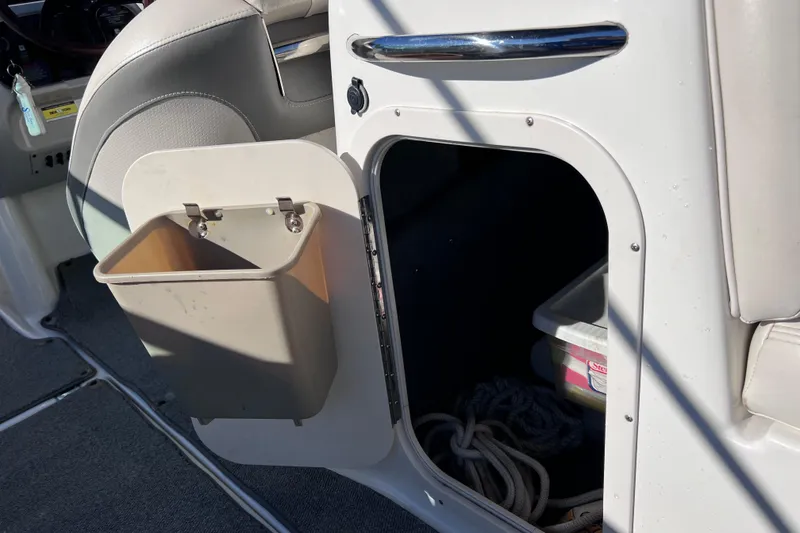 Slide: The Image of 2006 Chaparral 256 SSi boat interior storage compartment with trash bin and rope. - 50