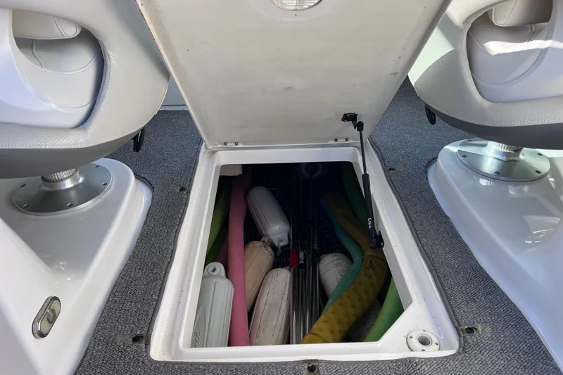 Slide: The Image of Storage compartment in 2006 Chaparral 256 SSi boat, containing pool noodles and fenders. - 51