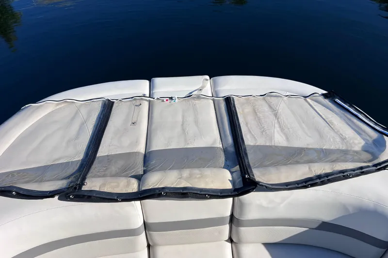 Slide: The Image of 2006 Chaparral 256 SSi boat with cushioned seating and clear protective cover on calm water. - 52