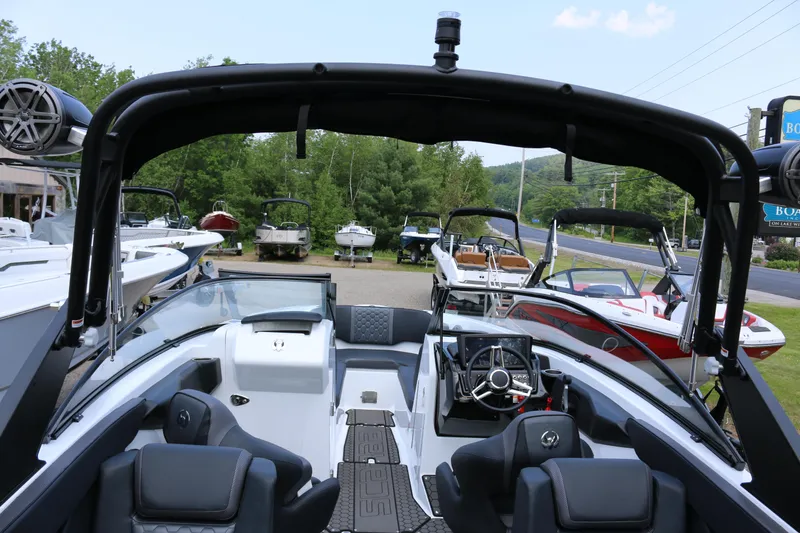 Slide: The Image of 2026 Scarab 255 LX boat interior with sleek design and modern features, parked outdoors. - 12
