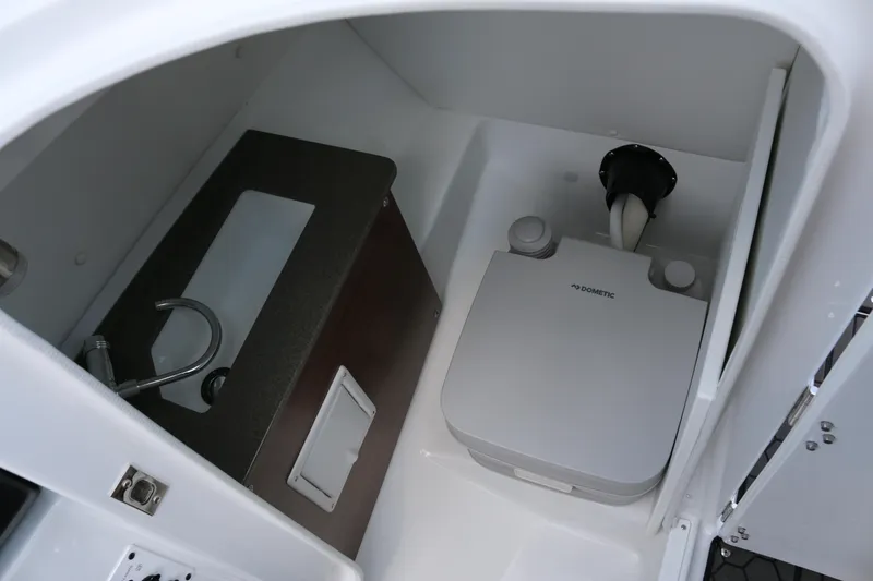 Slide: The Image of 2026 Scarab 255 LX boat interior with compact sink and portable toilet. - 21