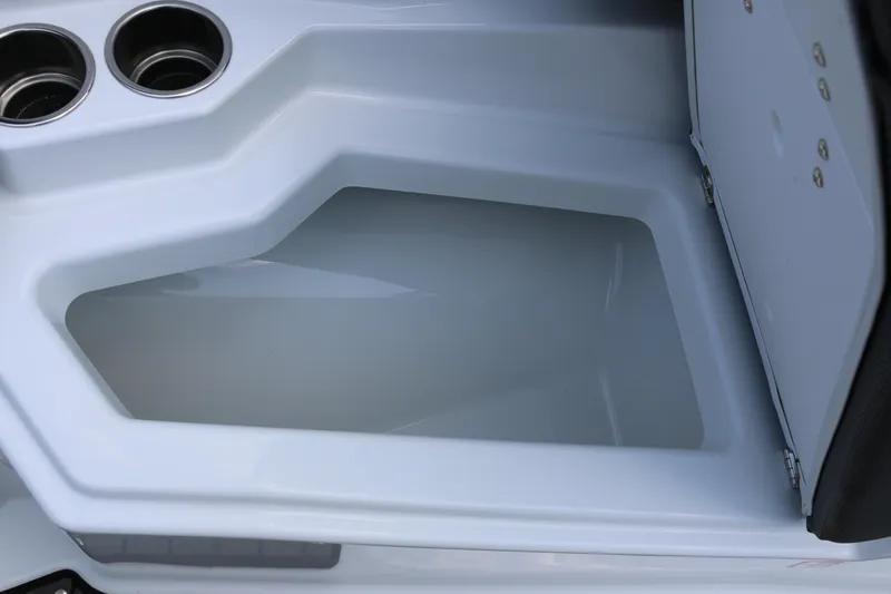 Slide: The Image of 2026 Scarab 255 LX boat storage compartment with cup holders, open lid. - 24