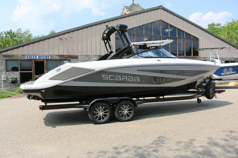Slide: The Image of 2026 Scarab 255 LX boat on trailer outside sales office, sleek design, modern features. - 5