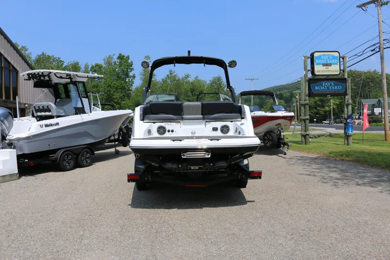 Slide: The Image of 2026 Scarab 255 LX boat displayed outdoors with other boats, showcasing rear view. - 6