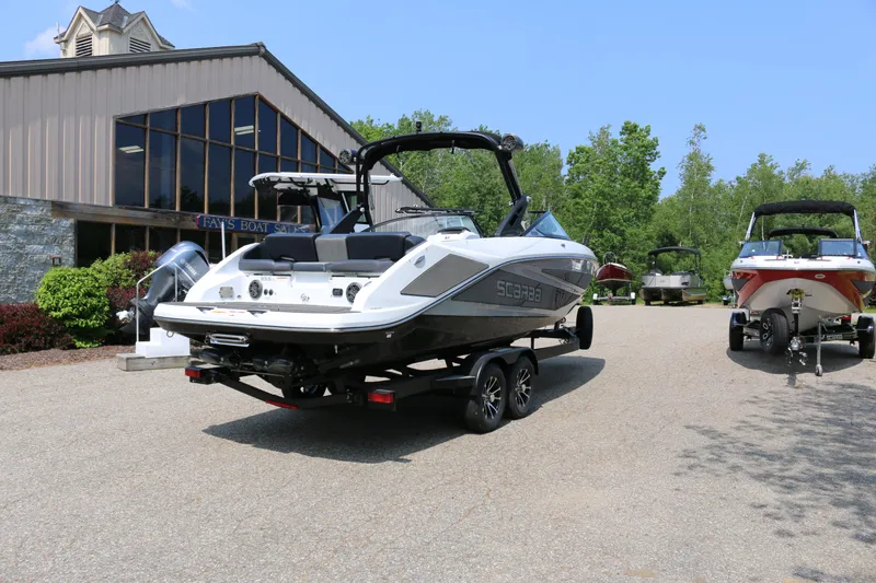 Slide: The Image of 2026 Scarab 255 LX boat on trailer outside dealership, sunny day. - 7