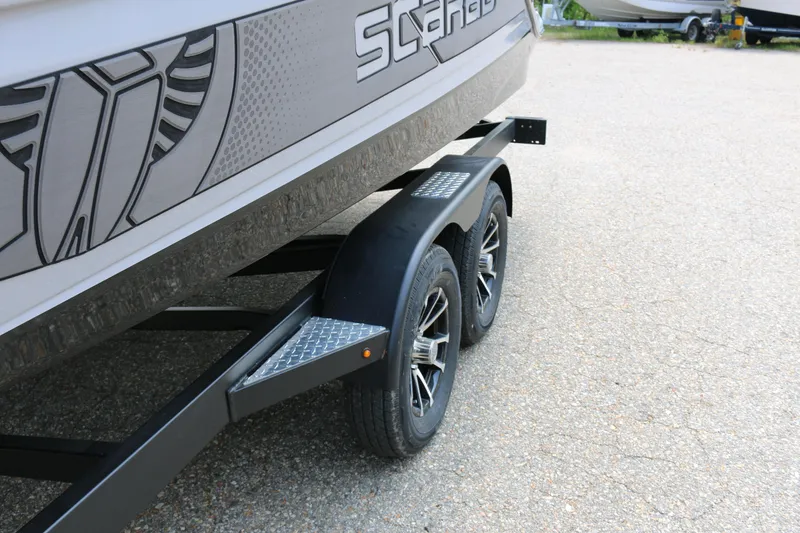 Slide: The Image of 2026 Scarab 255 LX boat on trailer, featuring dual wheels and sleek design. - 9