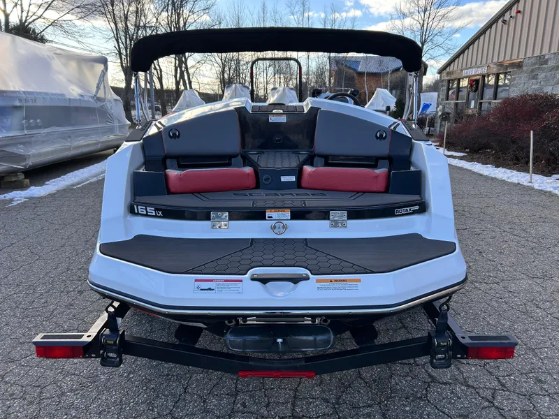 Slide: The Image of 2025 Scarab 165 LX boat on trailer, rear view, parked outdoors. - 10