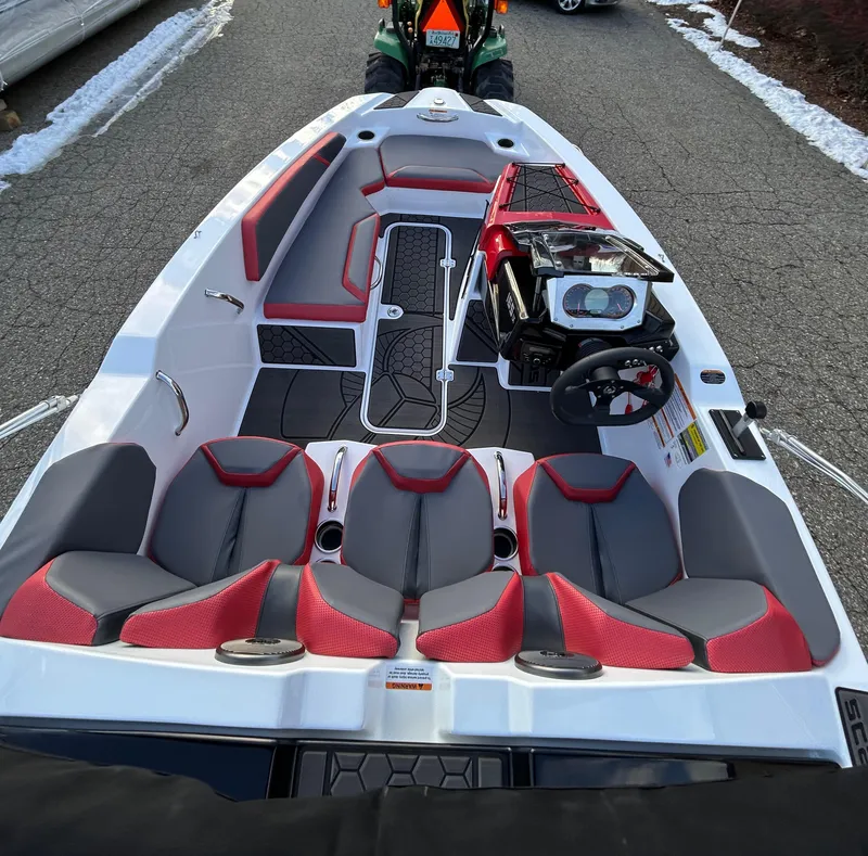 Slide: The Image of 2025 Scarab 165 LX boat interior with red and gray seating, steering console, and modern design. - 20