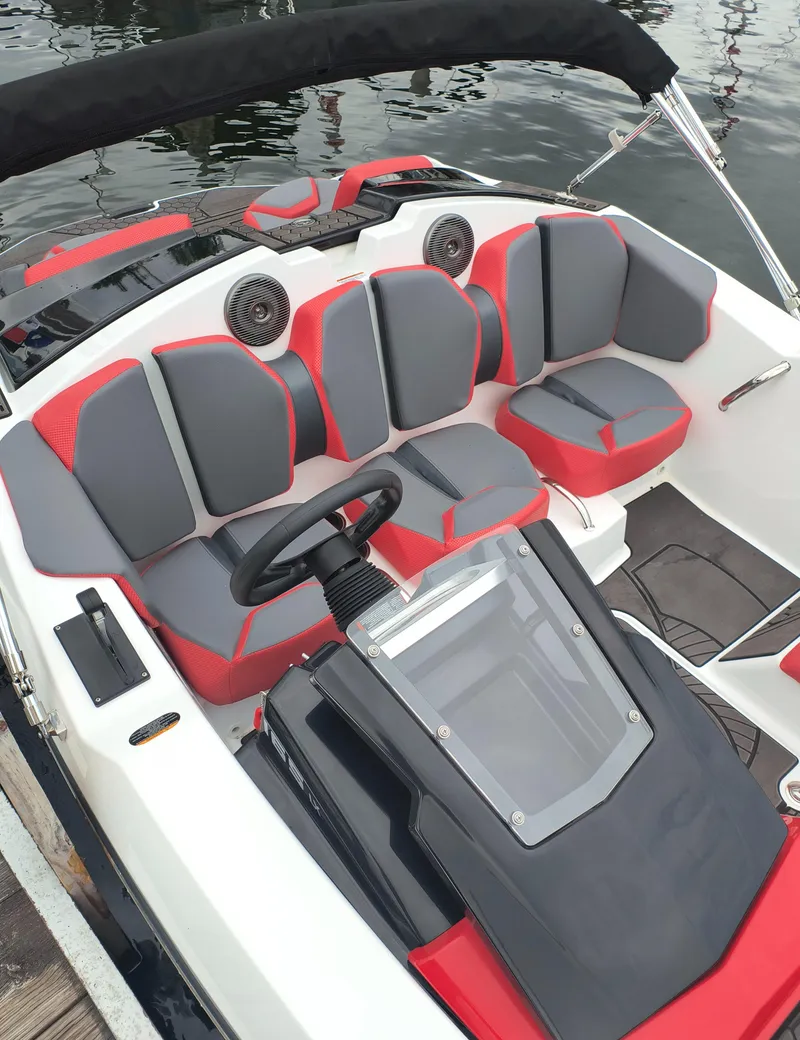 Slide: The Image of 2025 Scarab 165 LX boat interior with red and gray seating, steering wheel, and dashboard. - 5