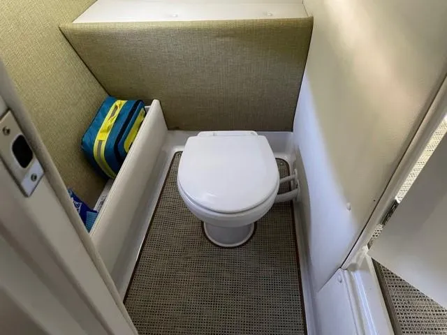 Slide: The Image of 2019 Cobalt R7 boat interior with compact toilet and storage area. - 11