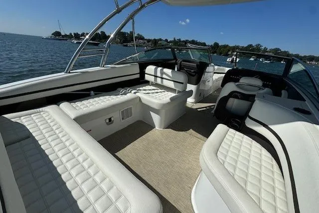 Slide: The Image of 2019 Cobalt R7 boat interior with white seating, on a sunny day by the water. - 2