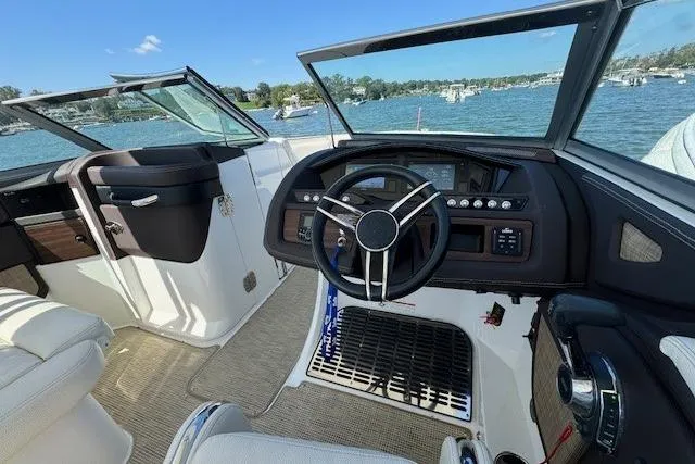 Slide: The Image of 2019 Cobalt R7 boat cockpit with steering wheel, dashboard, and lake view. - 6