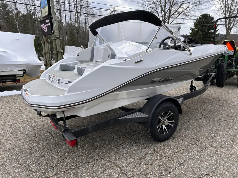 Slide: The Image of 2025 Scarab 165 SE boat on trailer, parked outdoors on a paved surface. - 6