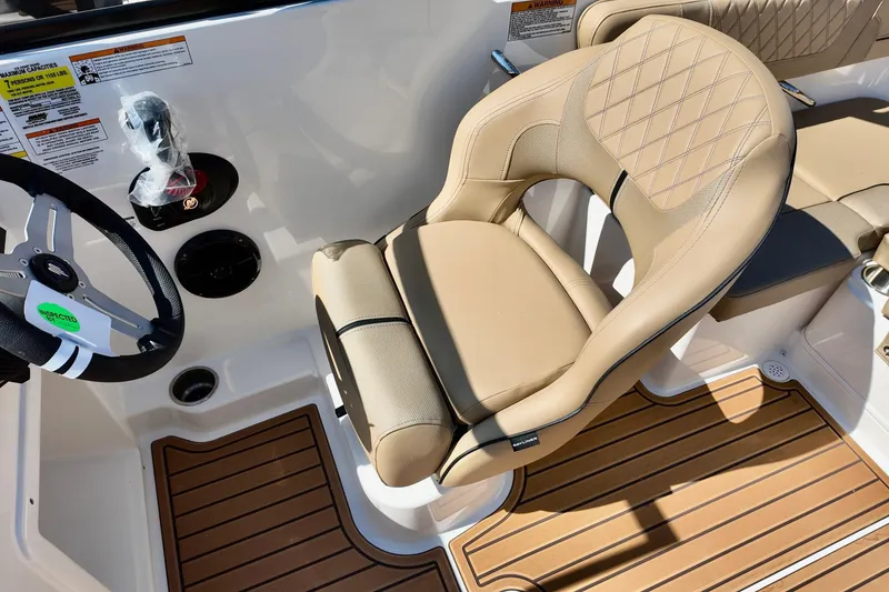 Slide: The Image of 2025 Bayliner VR4 Bowrider OB cockpit with tan seating and wood-style flooring. - 11