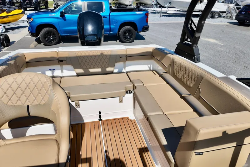 Slide: The Image of 2025 Bayliner VR4 Bowrider OB interior with tan seating and wood-style flooring. - 12