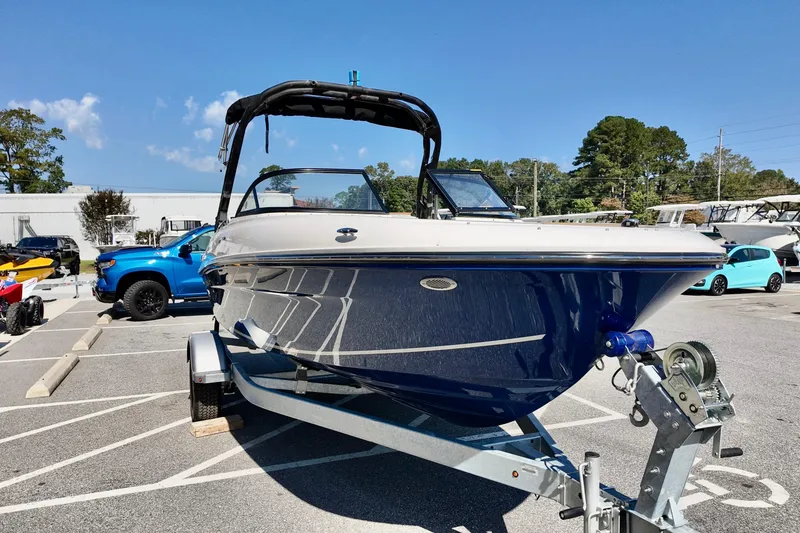 Slide: The Image of 2025 Bayliner VR4 Bowrider OB on trailer, parked outdoors under clear blue sky. - 3