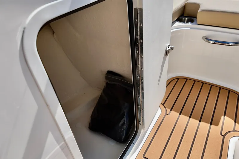 Slide: The Image of 2025 Bayliner VR4 Bowrider OB storage compartment with teak flooring and open door. - 7