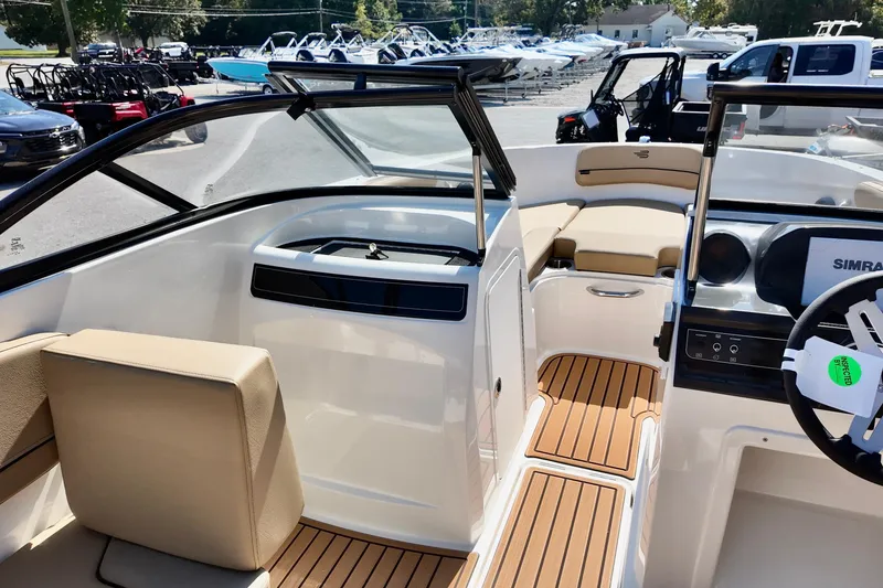Slide: The Image of 2025 Bayliner VR4 Bowrider OB interior with tan seating and modern dashboard. - 9