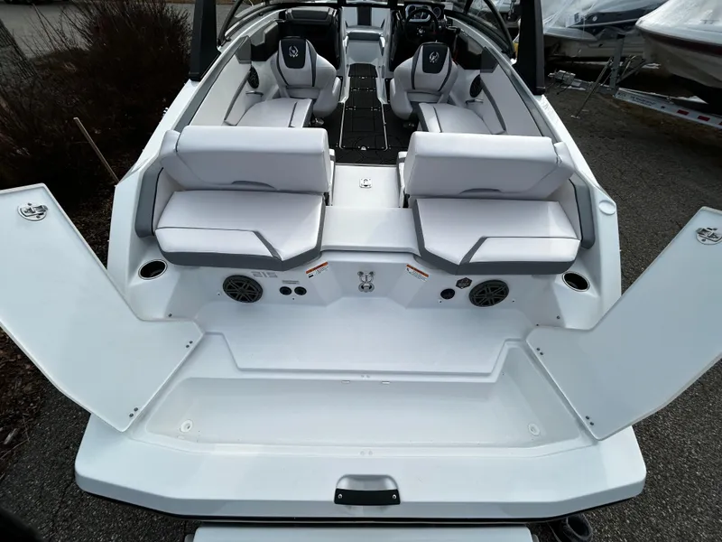 Slide: The Image of 2024 Scarab 215 Wake LE boat interior with white seating and open storage compartments. - 7