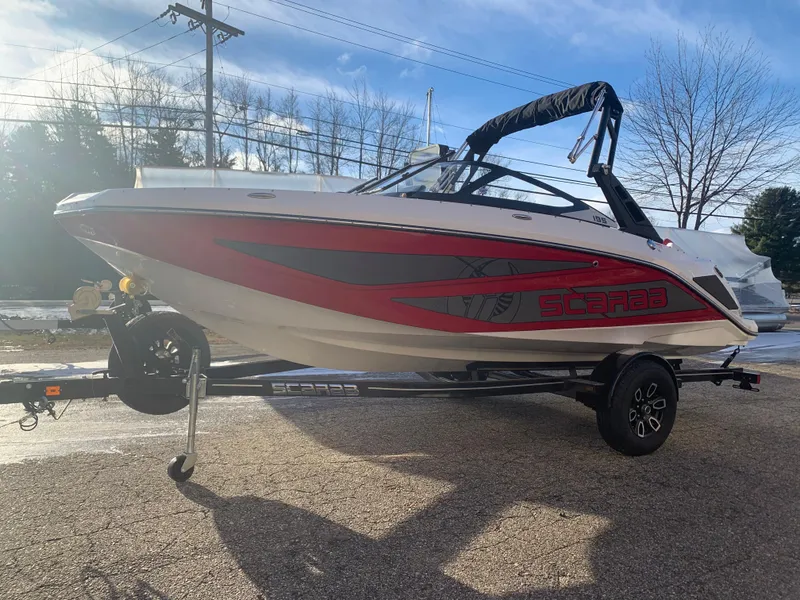 Slide: The Image of 2023 Scarab 195 ID boat on a trailer, red and white exterior. - 3